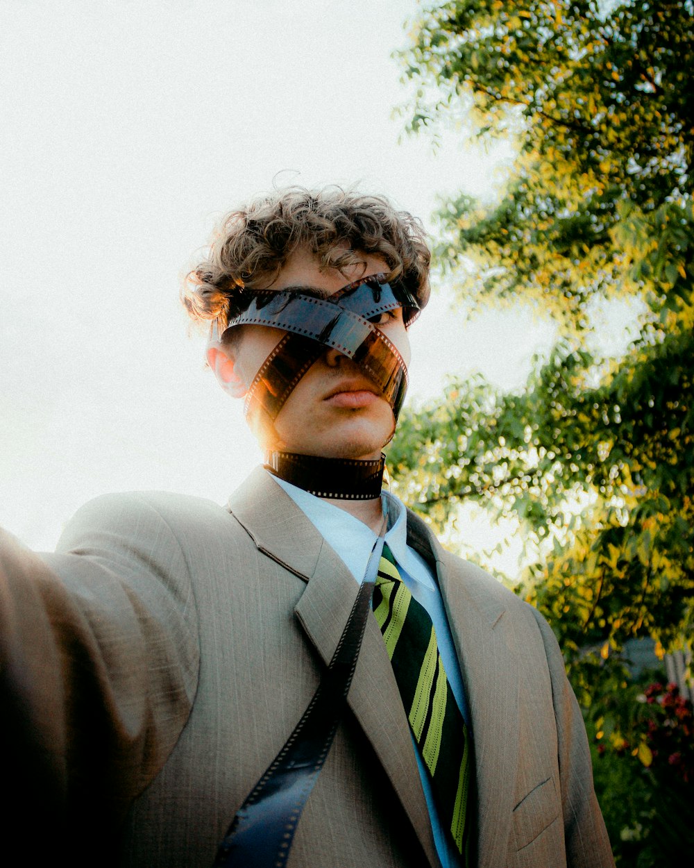 a man in a suit and tie with a blindfold on his face
