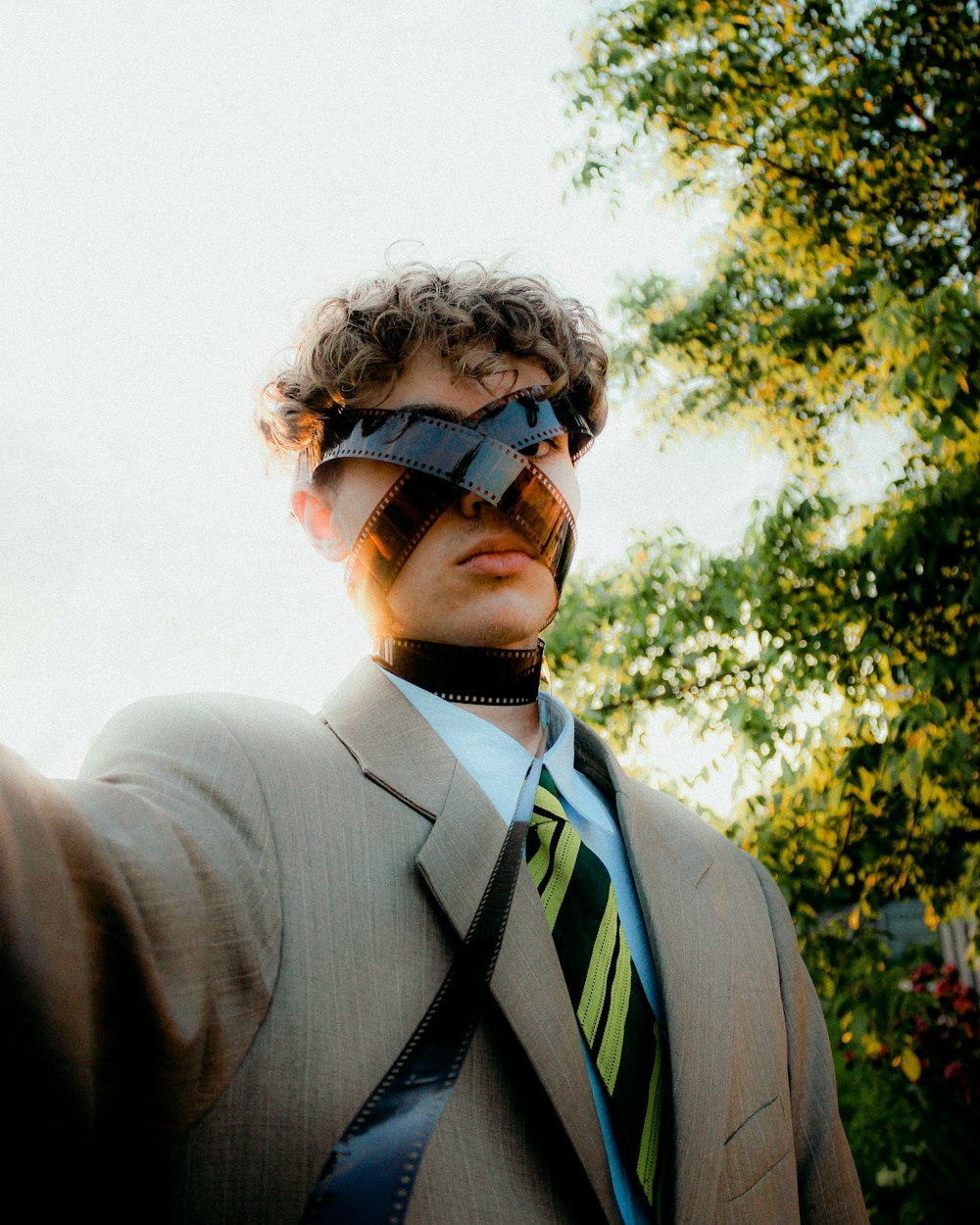 Un hombre con traje y corbata con los ojos vendados en la cara