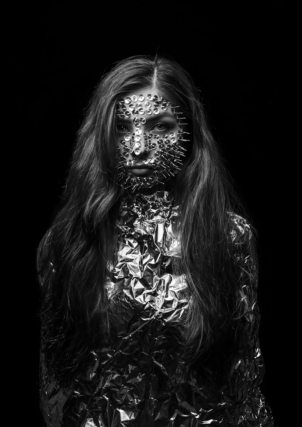 a black and white photo of a woman covered in tin foil