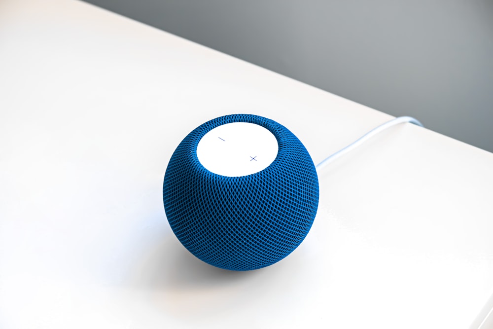 a blue speaker sitting on top of a white table