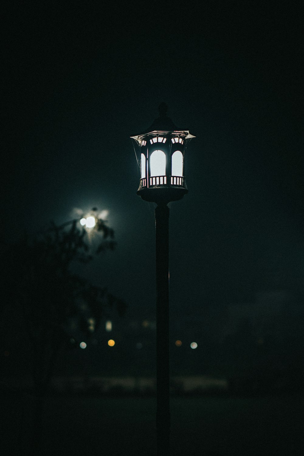 a lamp post lit up at night in the dark