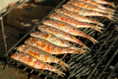 Grilled fish sizzling on a pan, representing turmeric grilled fish (cha ca) cuisine