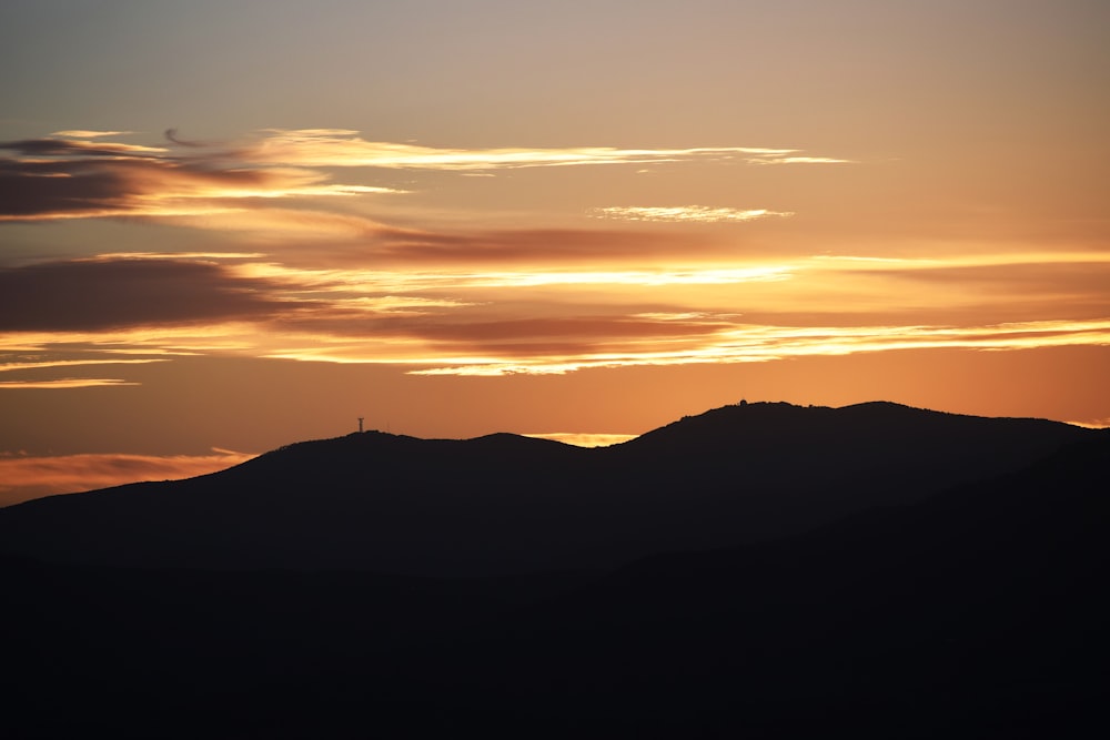 the sun is setting over a mountain range