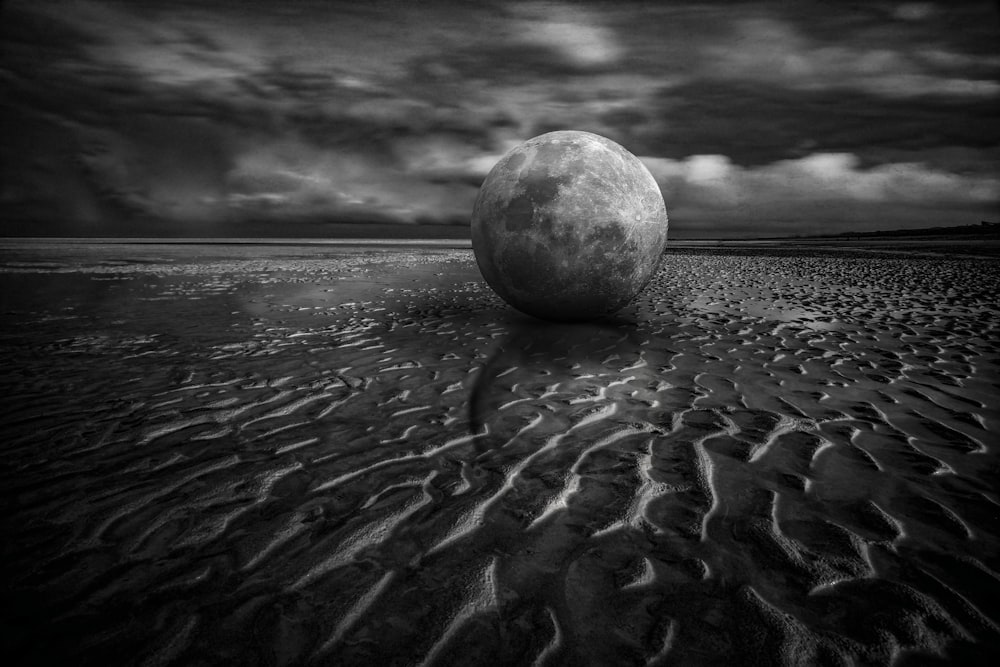 a large ball sitting on top of a sandy beach