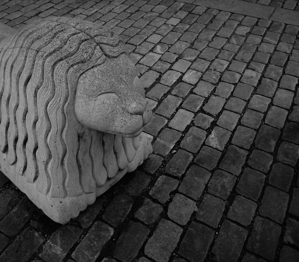 a statue of a lion on a brick road