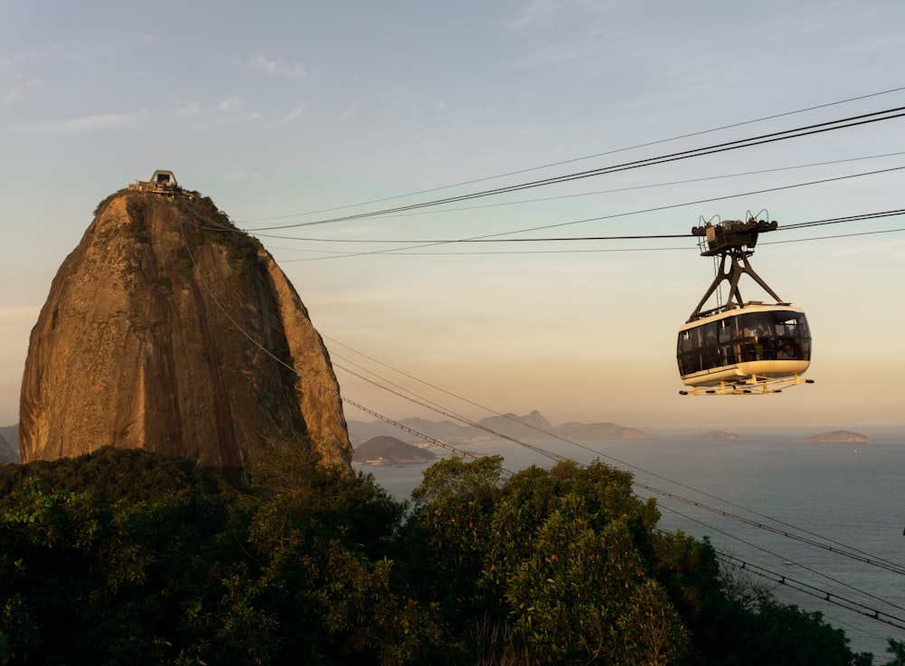 a cable car going up a mountain with a view of the ocean