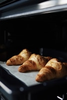 A close-up of golden-brown croissants fresh from the oven.