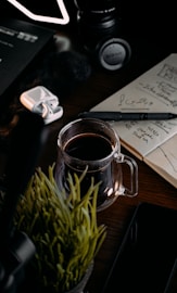 A cozy workspace featuring a mockup of a branded notebook and coffee cup on a rustic table.