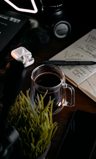 A warm, inviting workspace with a notebook, pen, and a cup of tea on a wooden desk.