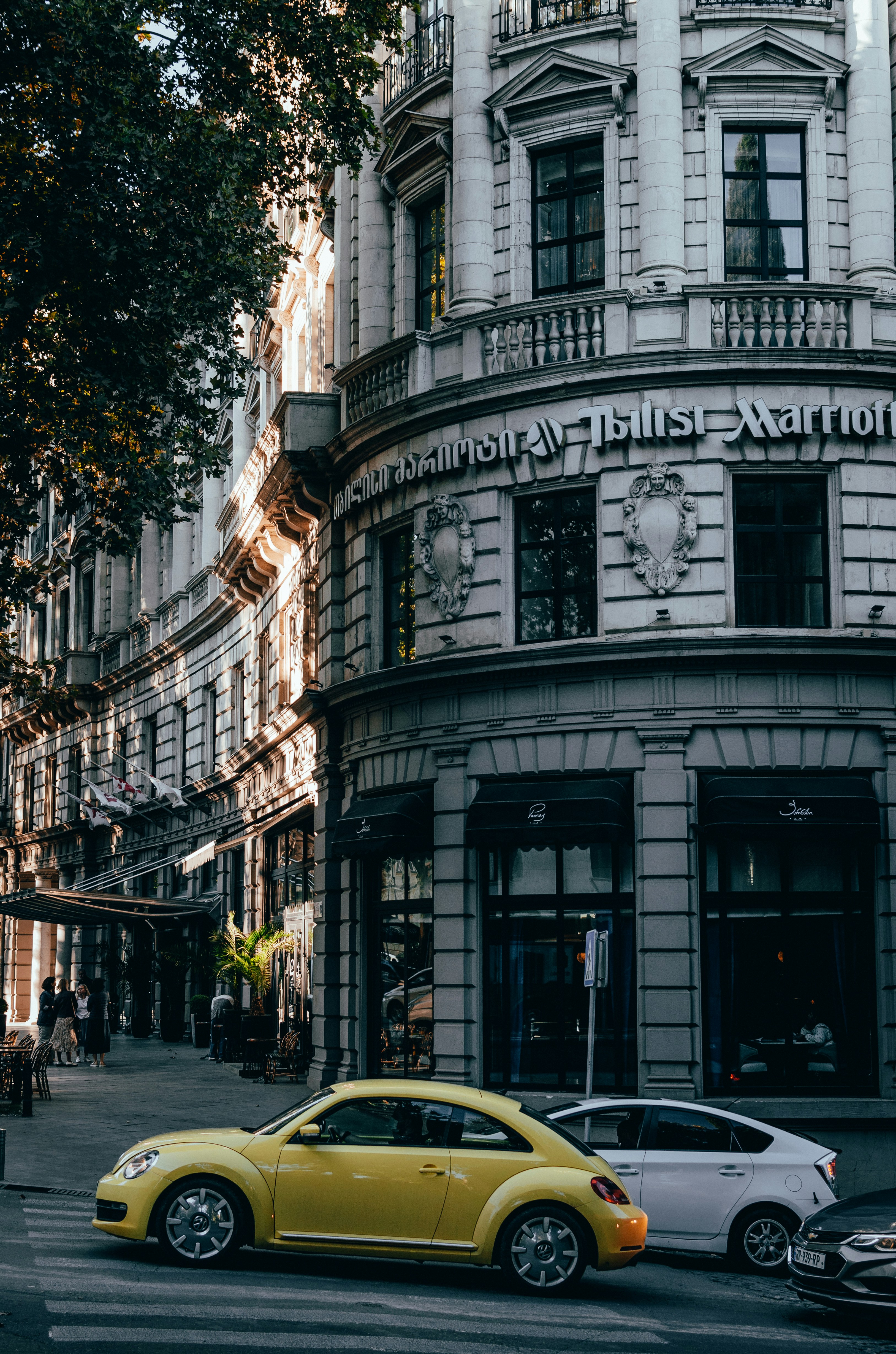 a yellow car is parked in front of a building