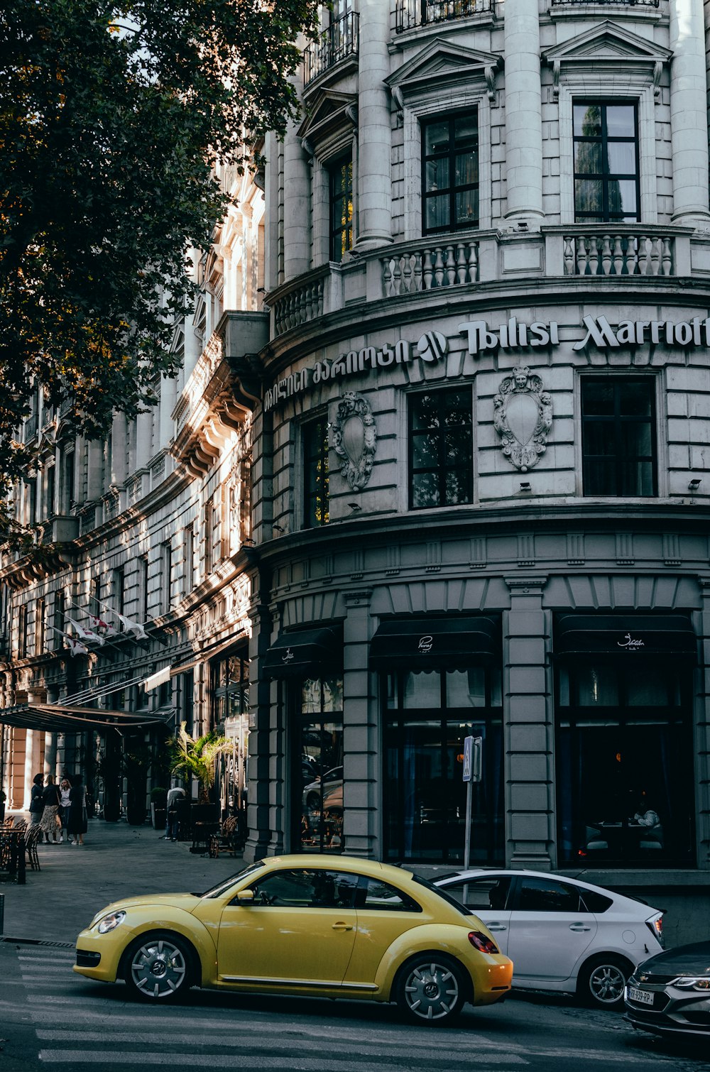 a yellow car is parked in front of a building