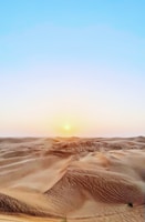 Golden dunes glowing under a sunset sky during a desert safari.