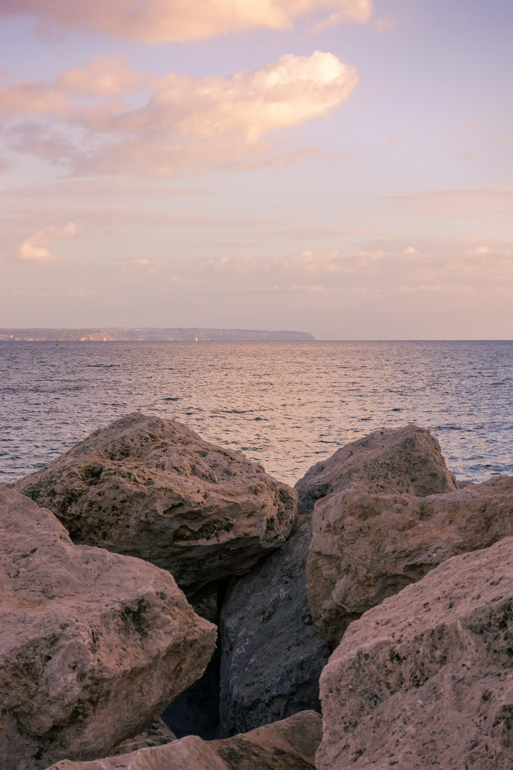 a rock formation with a body of water in the background