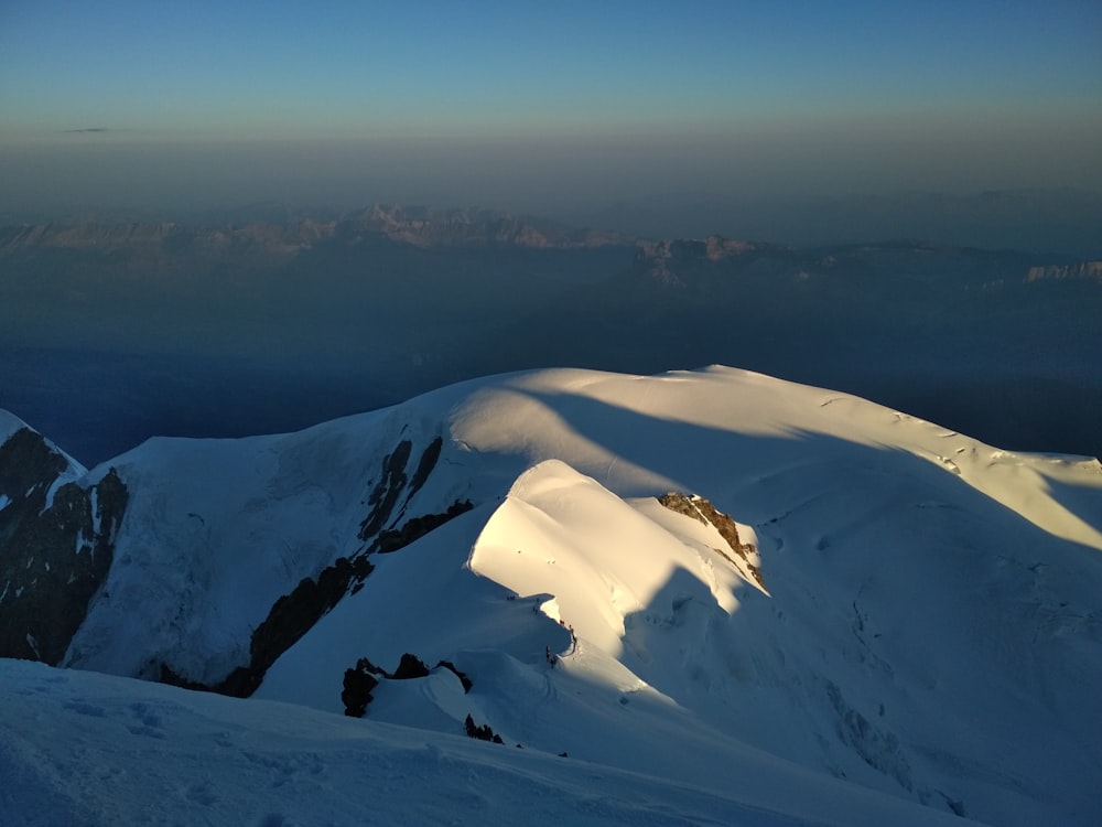 a view of a snowy mountain with mountains in the background