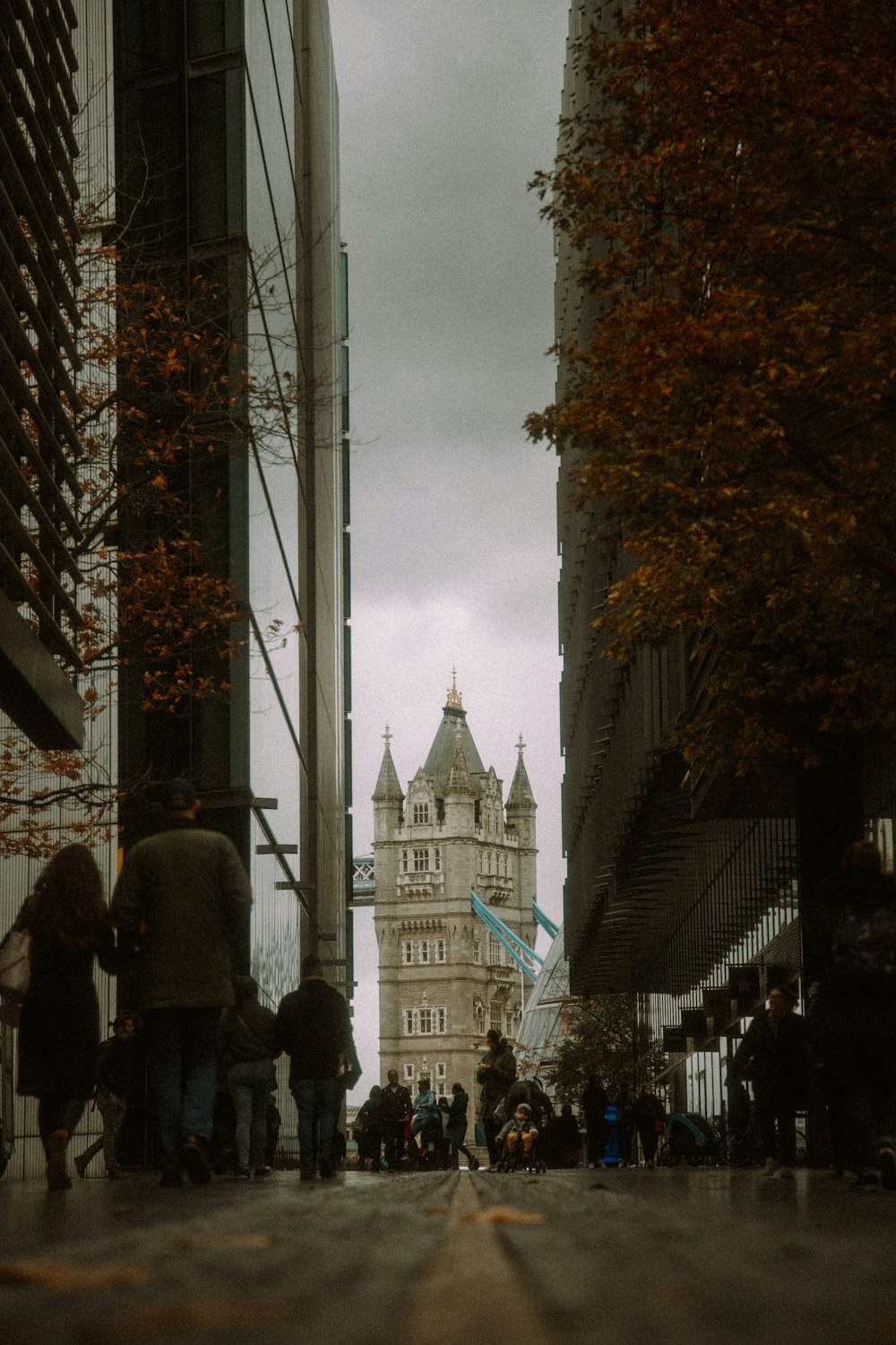 a group of people walking down a street next to tall buildings