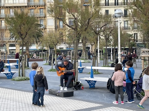 A guitarist teaching children at a school.