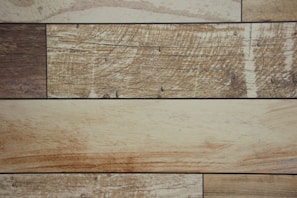 Several rectangular wooden planks arranged horizontally, each displaying a unique grain pattern and varying shades of brown with visible textures.