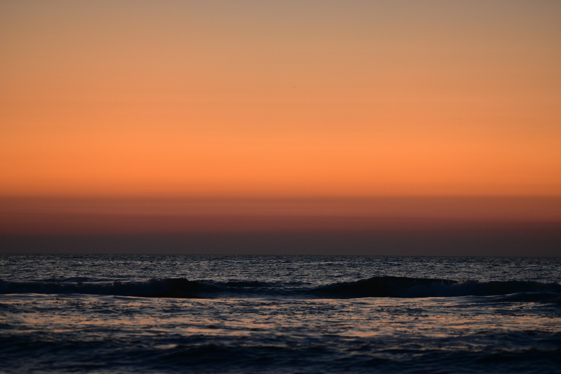 a sunset over a body of water with waves