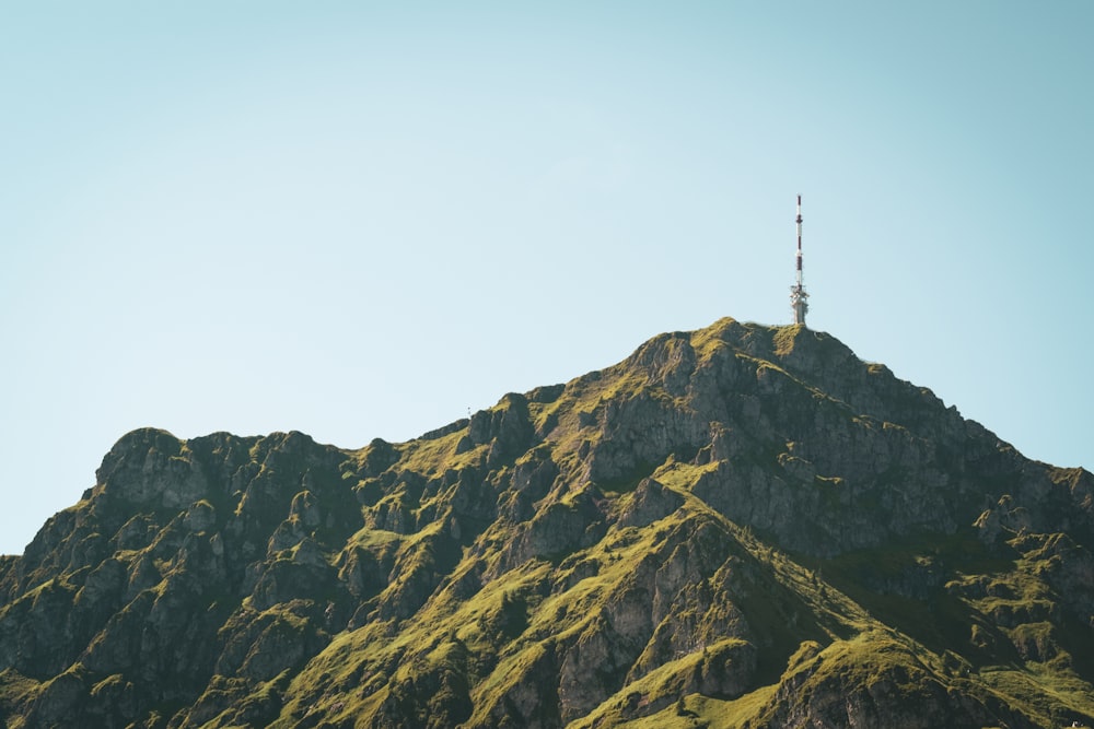 ein hoher Berg mit einem Funkturm darauf