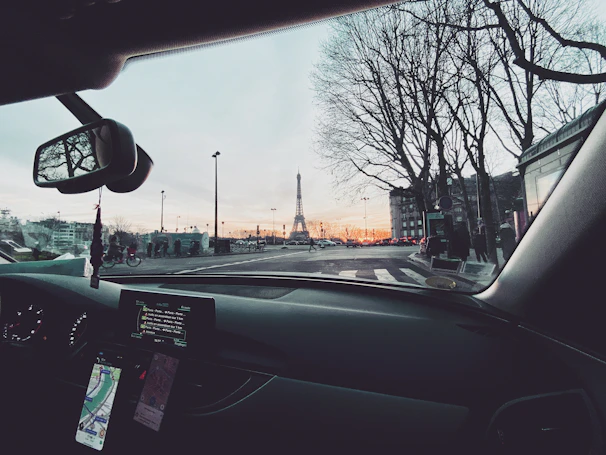 A serene city street at dusk, seen from inside an Élancia vehicle, emphasizing a secure and peaceful journey.