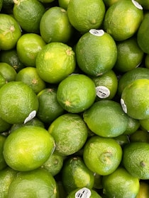 Workers carefully selecting and packing fresh limes into export boxes.