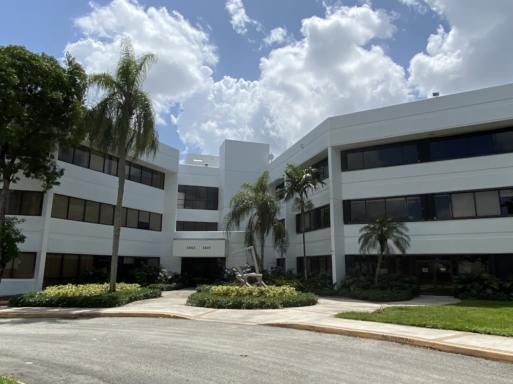 a white building with palm trees in front of it