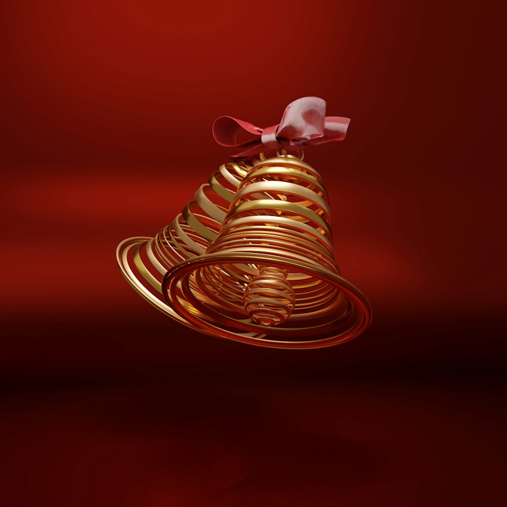 a golden bell with a bow on a red background