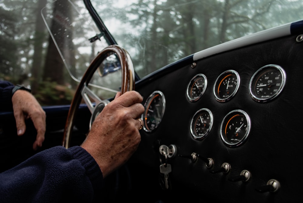 a man driving a car with a steering wheel