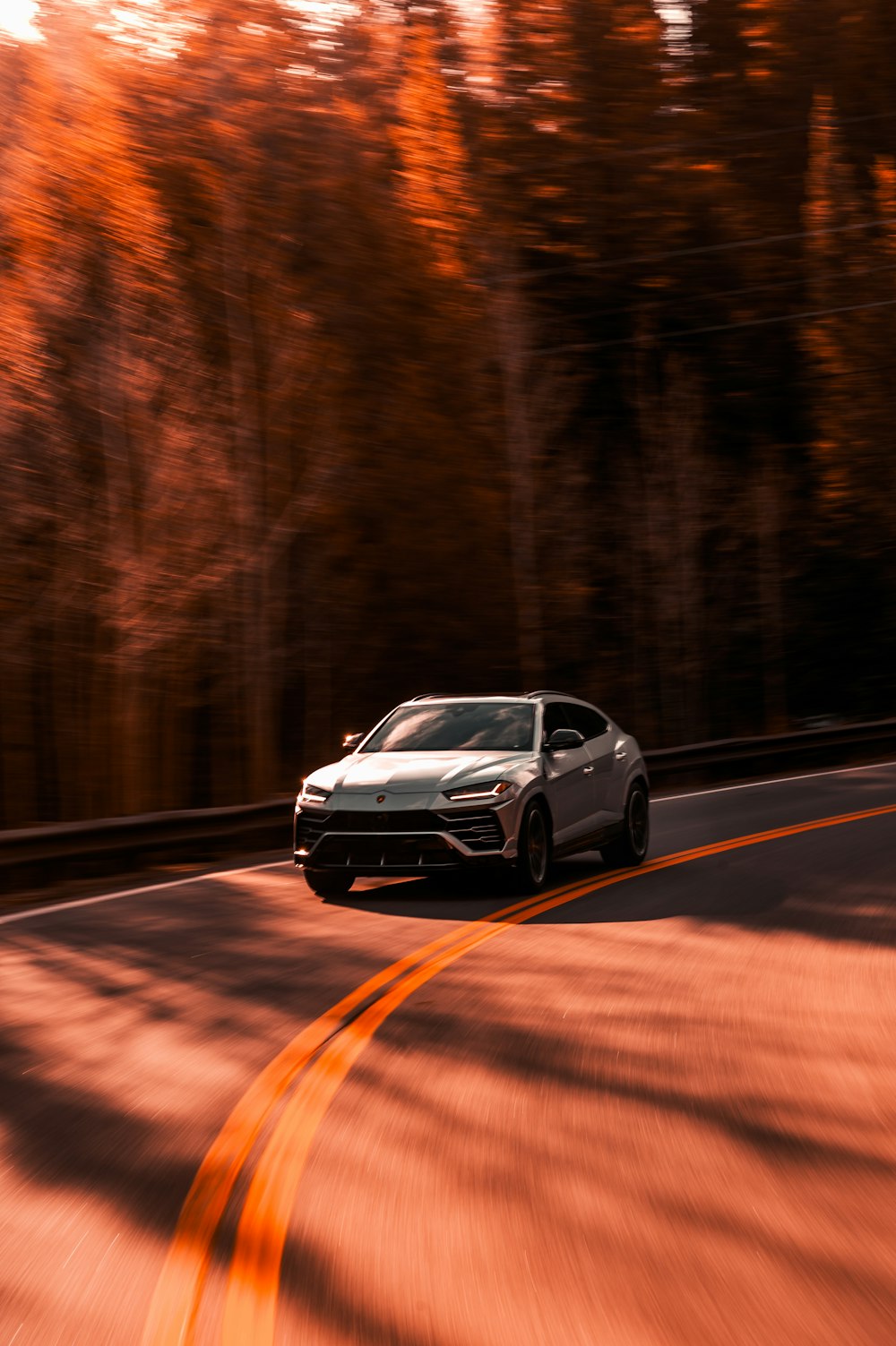 a white car driving down a curvy road