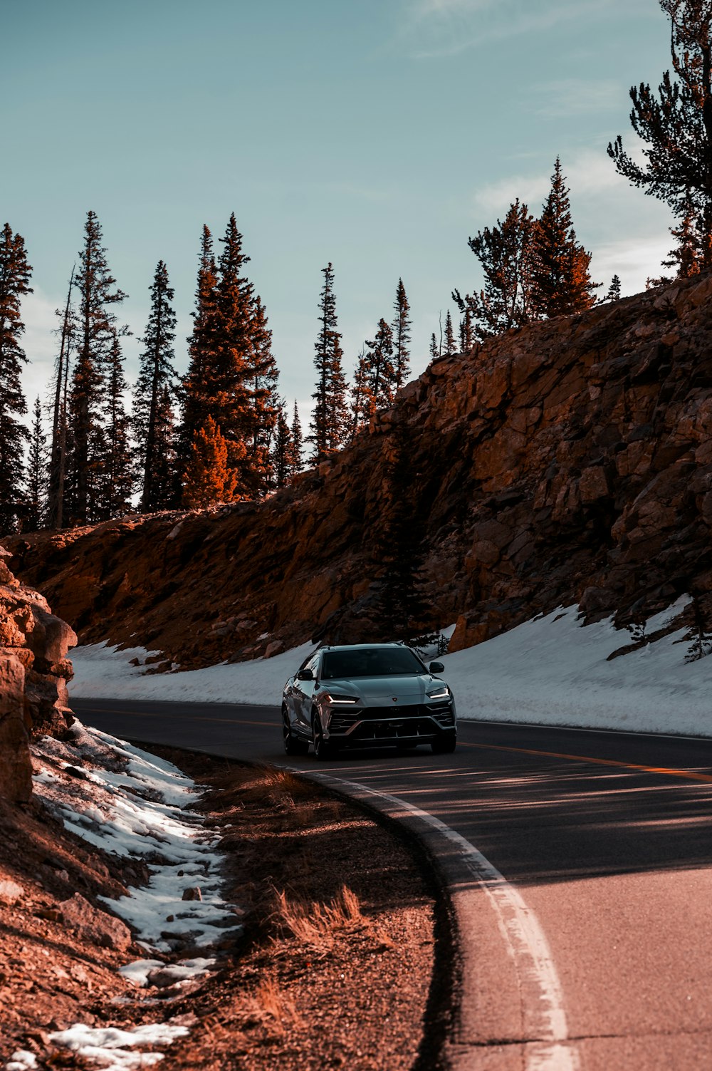 a car driving down a road in the mountains