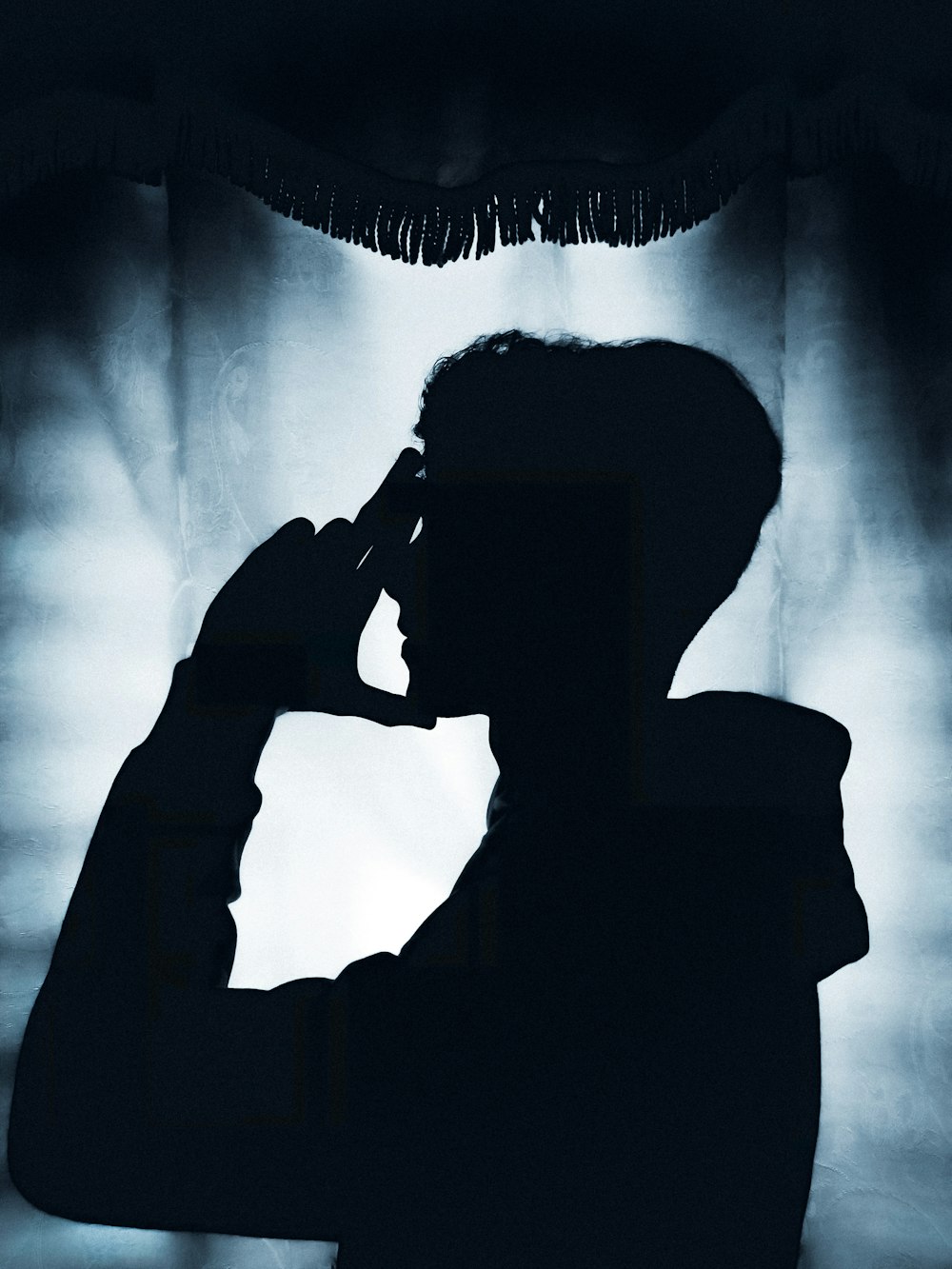 a silhouette of a man talking on a cell phone