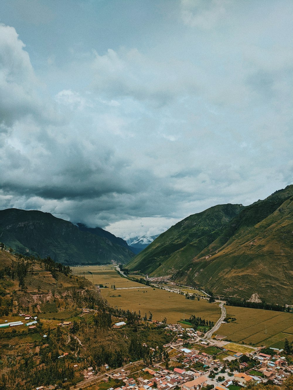 a scenic view of a valley with mountains in the background