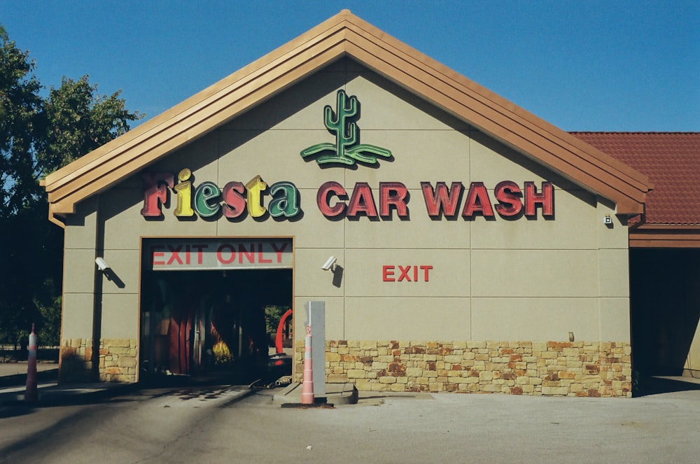 Un edificio de lavado de autos con un letrero que dice Fiesta Car Wash