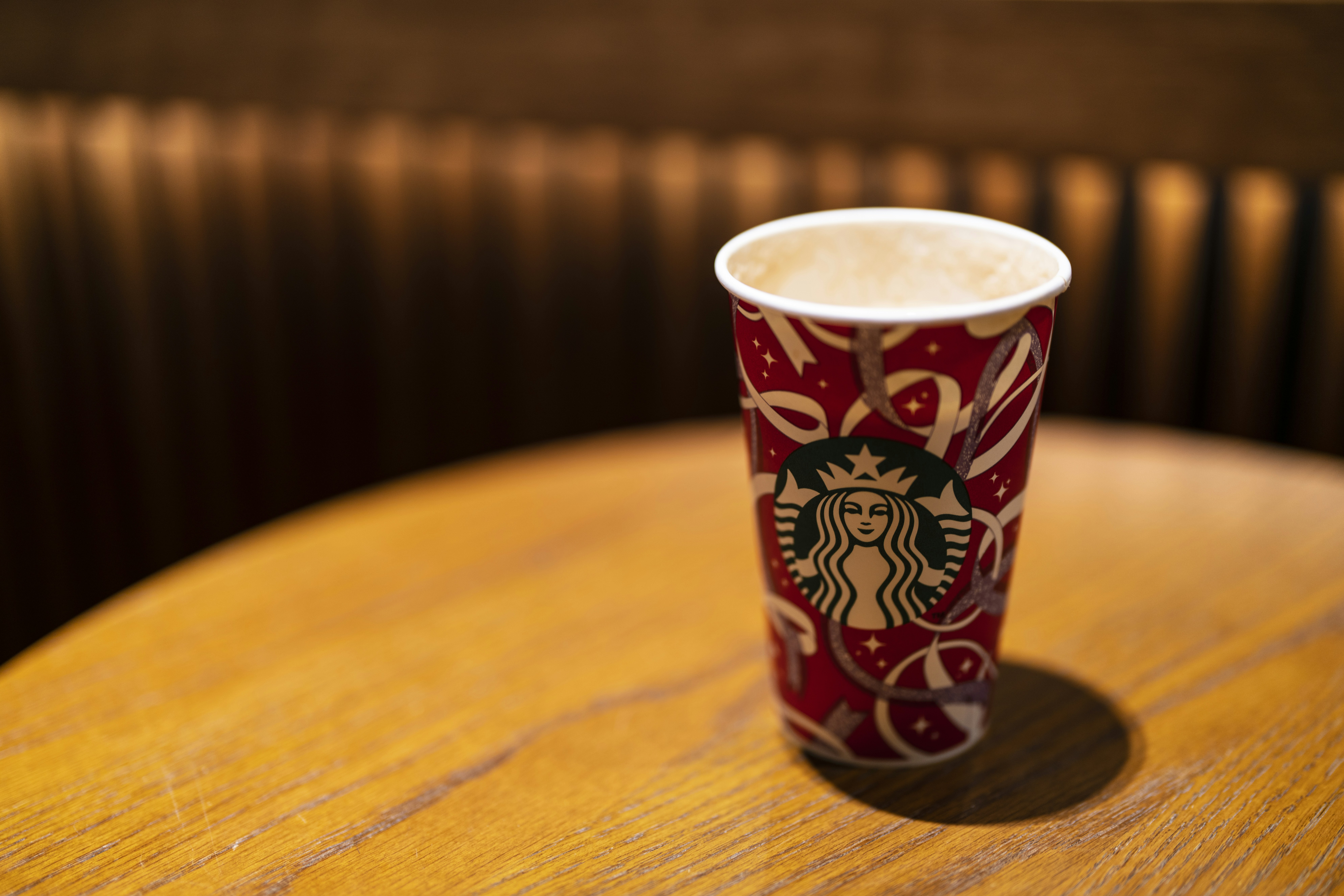 a starbucks cup sitting on top of a wooden table