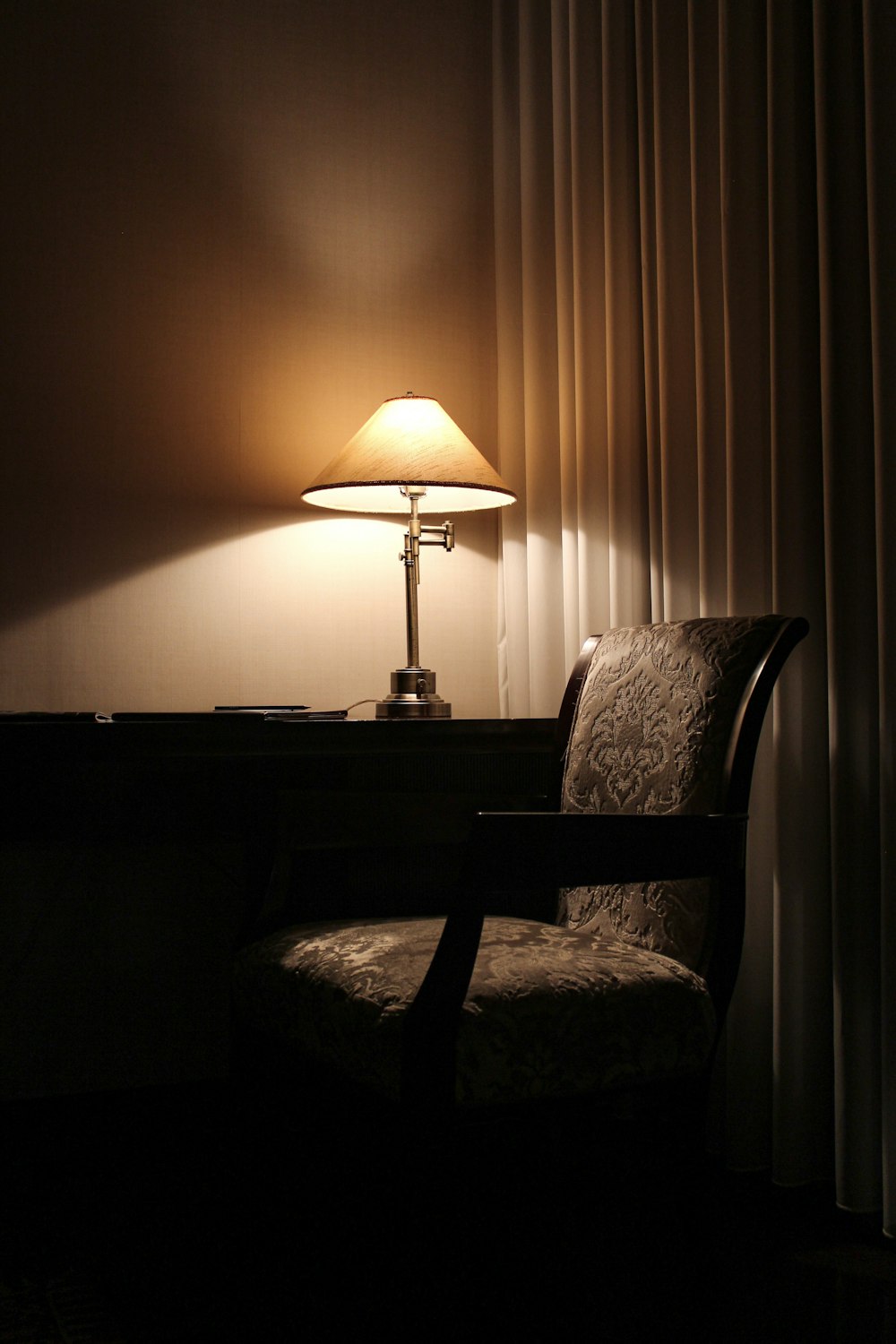 a chair and a lamp in a dark room