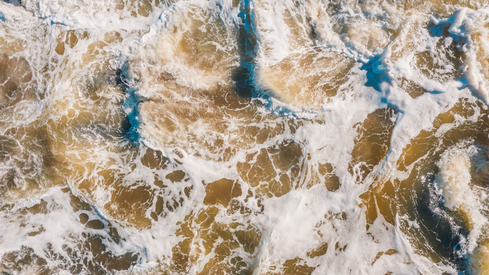 an aerial view of the ocean waves and sand