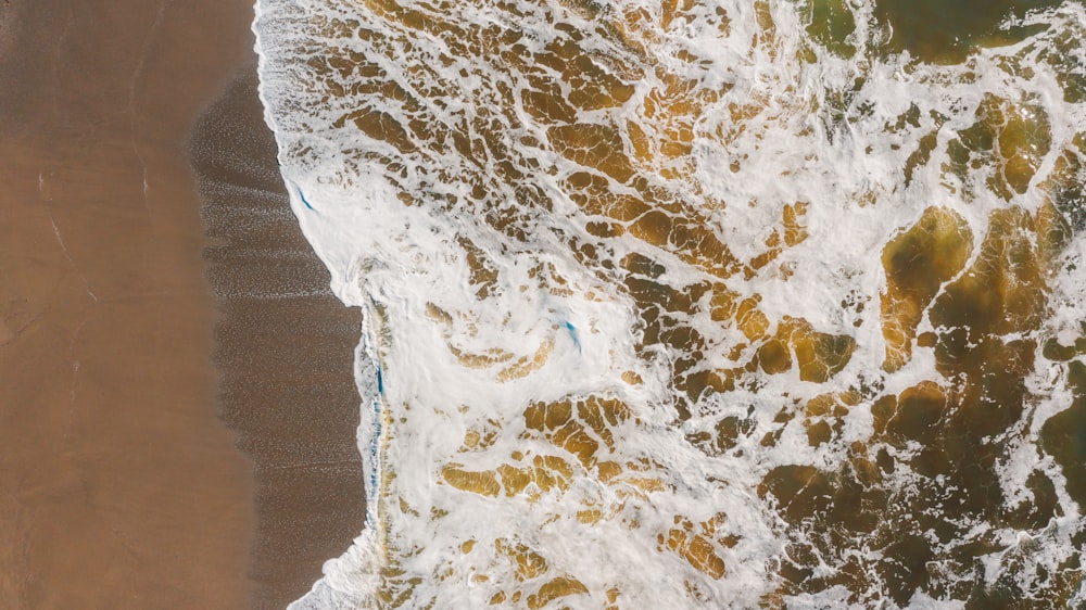 an aerial view of a beach with waves crashing on it