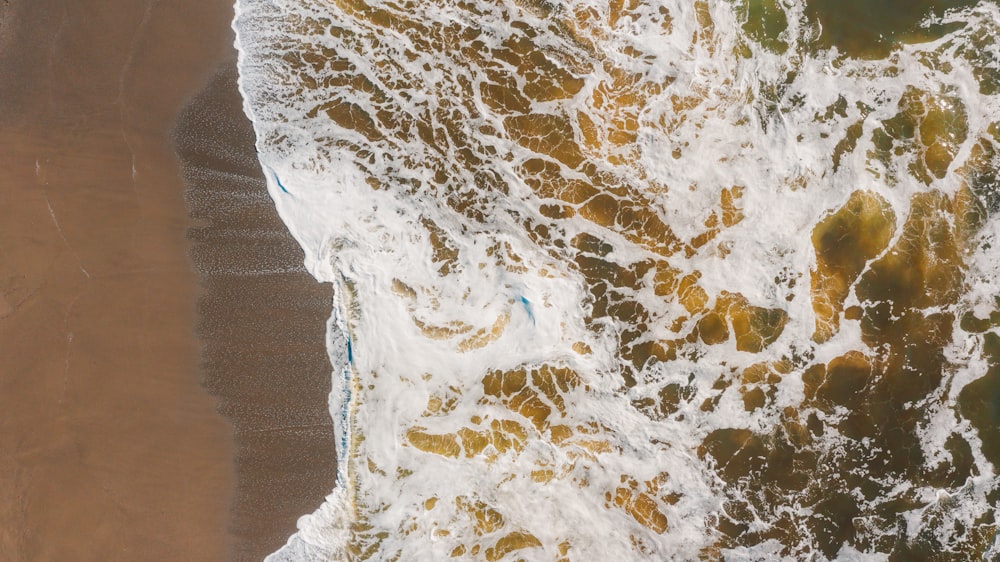 una vista aerea di una spiaggia con onde che si infrangono su di essa