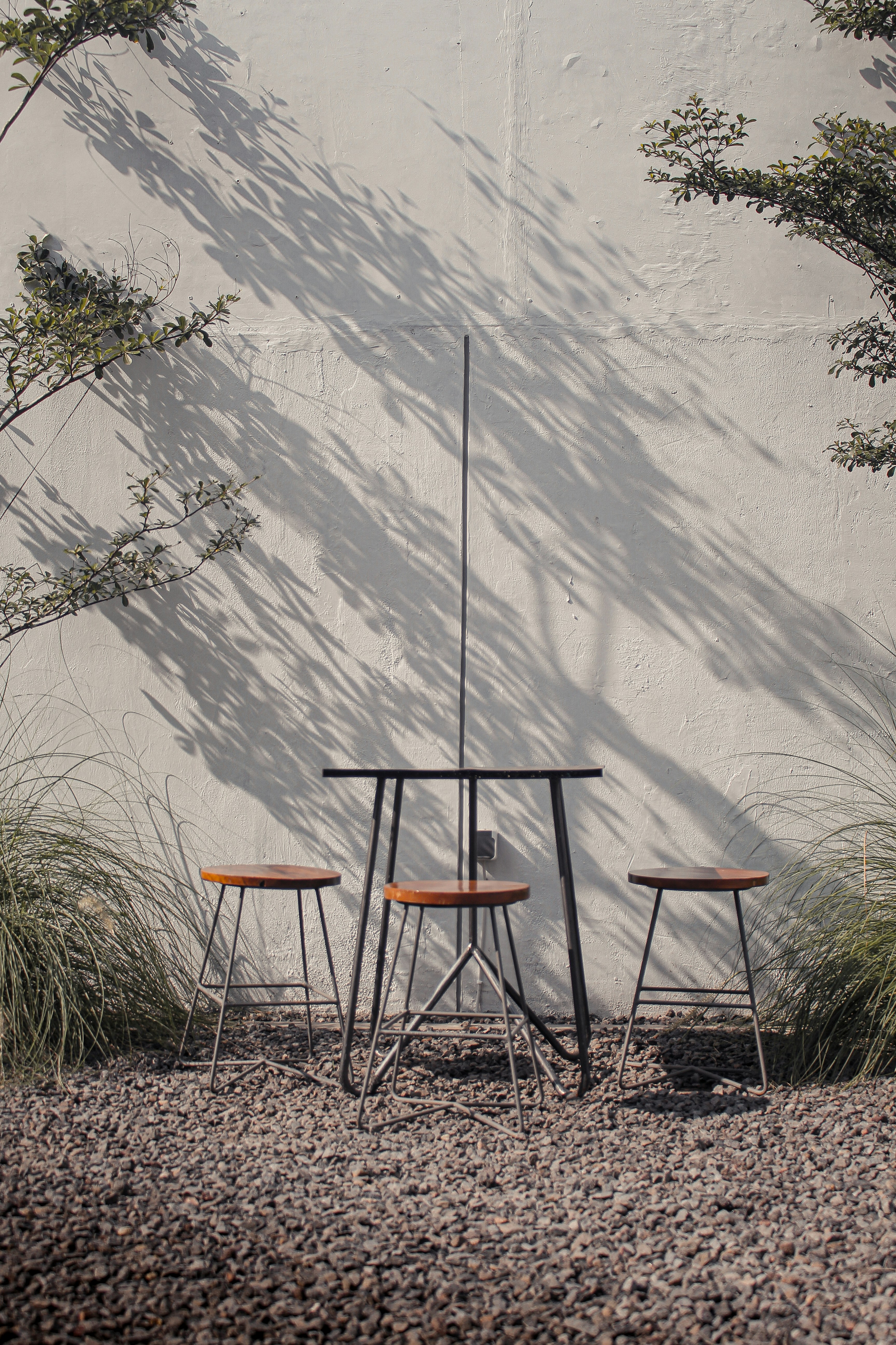 three chairs and a table in front of a white wall