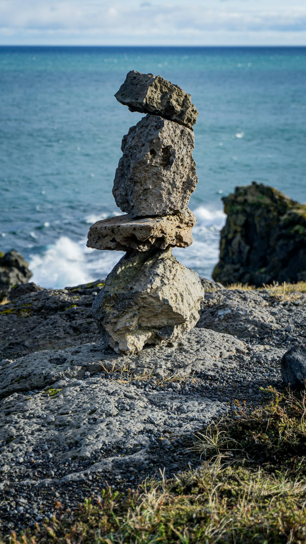 Una pila de rocas sentadas en la cima de una playa rocosa