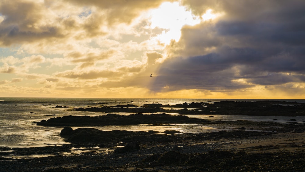 the sun is shining through the clouds over the ocean