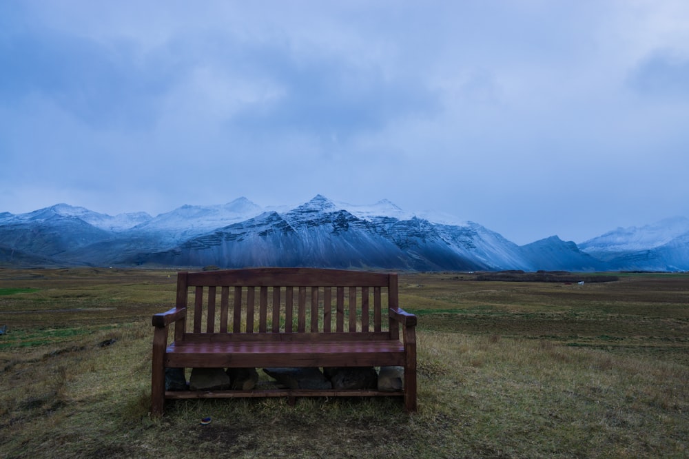a wooden bench sitting in the middle of a field