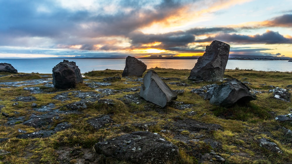 Un grupo de rocas sentadas en la parte superior de un campo cubierto de hierba