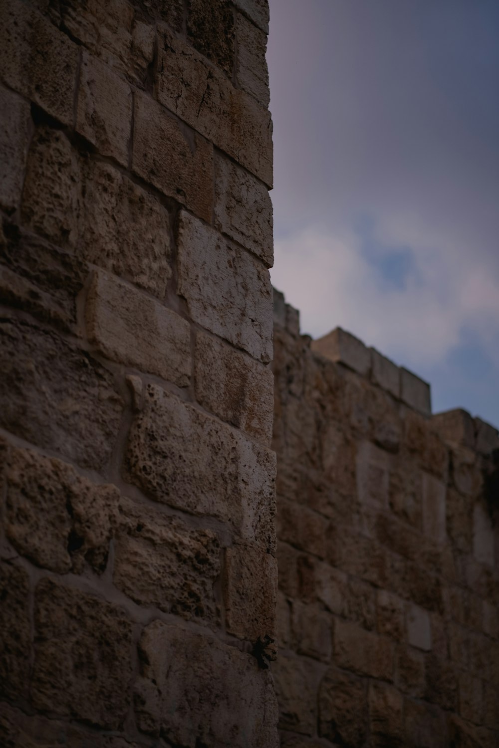 a close up of a brick wall with a sky in the background