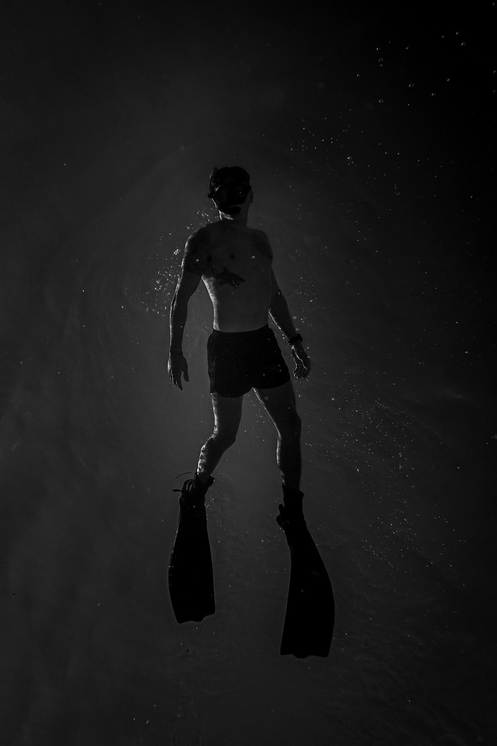 a person carrying a surf board in the dark