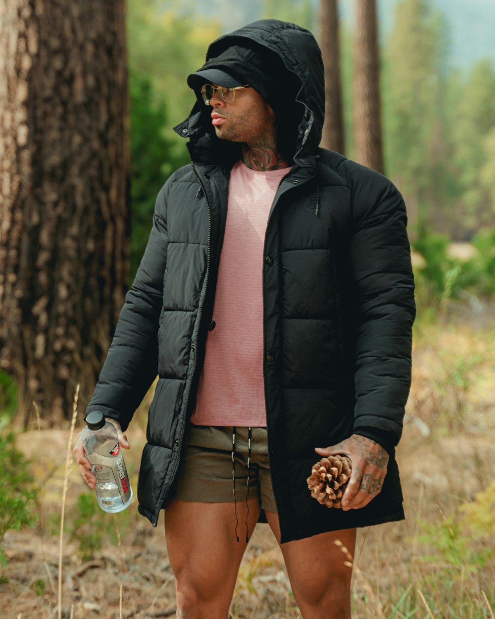 a man standing in the woods with a bottle of water
