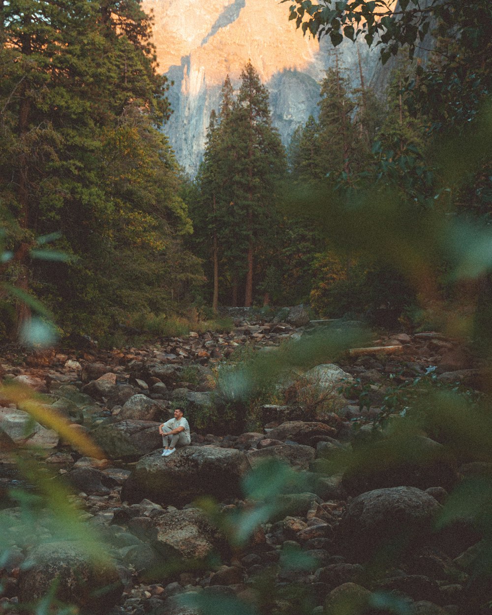 a couple of people standing on top of a rocky river