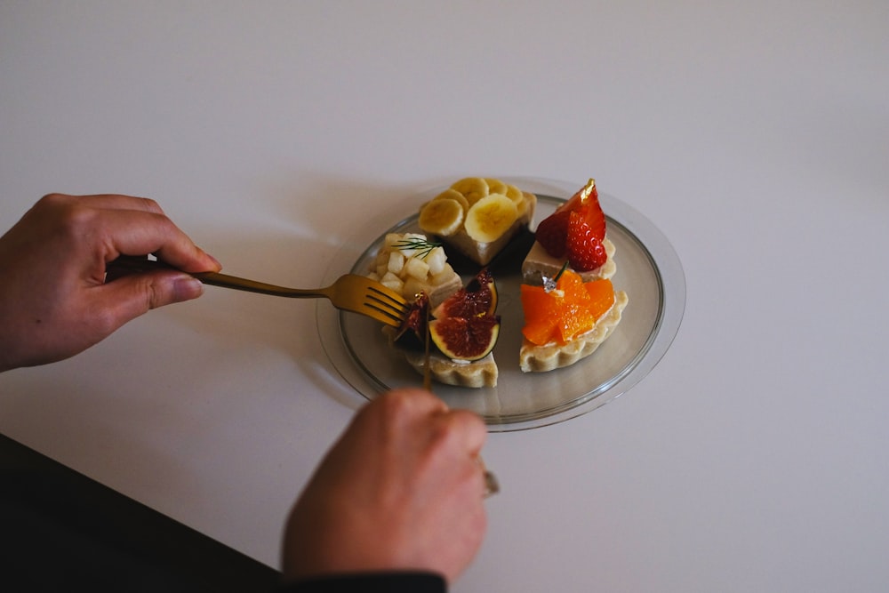 a person holding a spoon over a plate of food