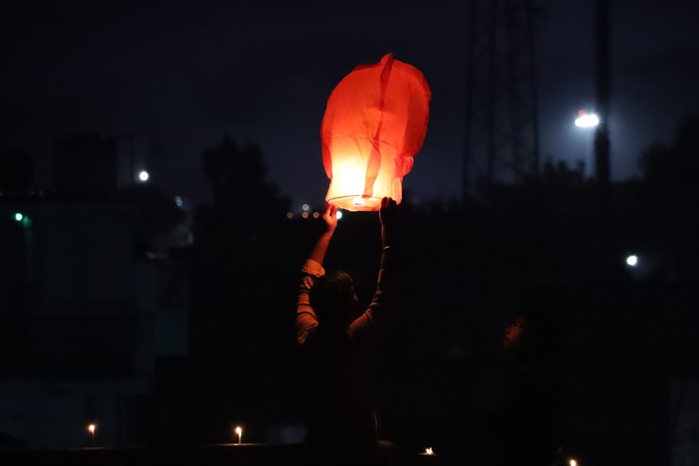 a person holding a lantern in the dark