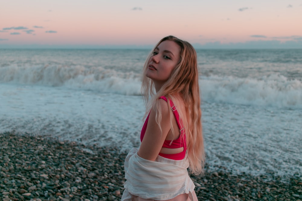 a woman standing on a beach next to the ocean